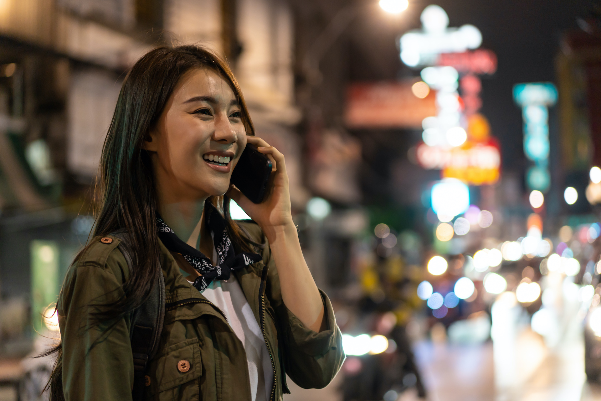 Ασιάτισσα ταξιδιώτης που μιλάει στο κινητό τηλέφωνο περπατώντας στην πόλη.